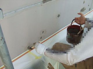 外壁がところどころ腐食している箇所に防水塗料を塗る